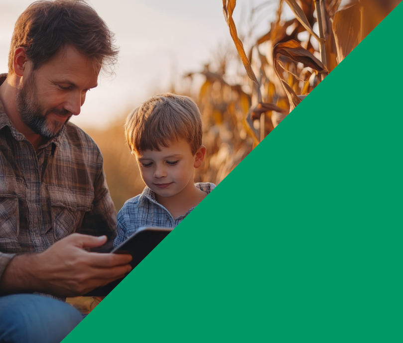 Vater und Sohn mit Tablet im Maisfeld bei Sonnenuntergang